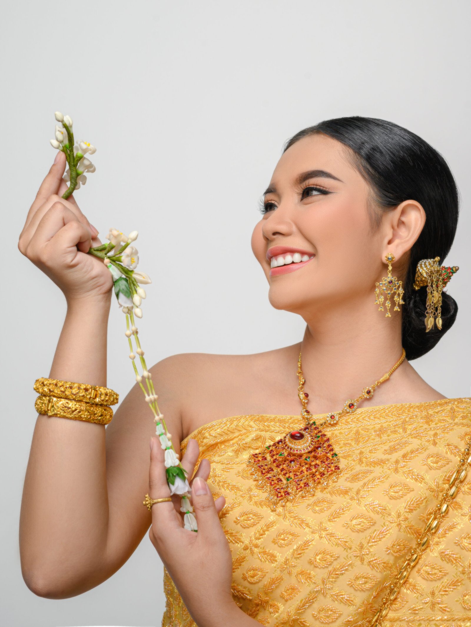 Close up, Portrait beautiful Asian woman in traditional Thai dress costume smile and holding a garland with gracefully pose on white background
